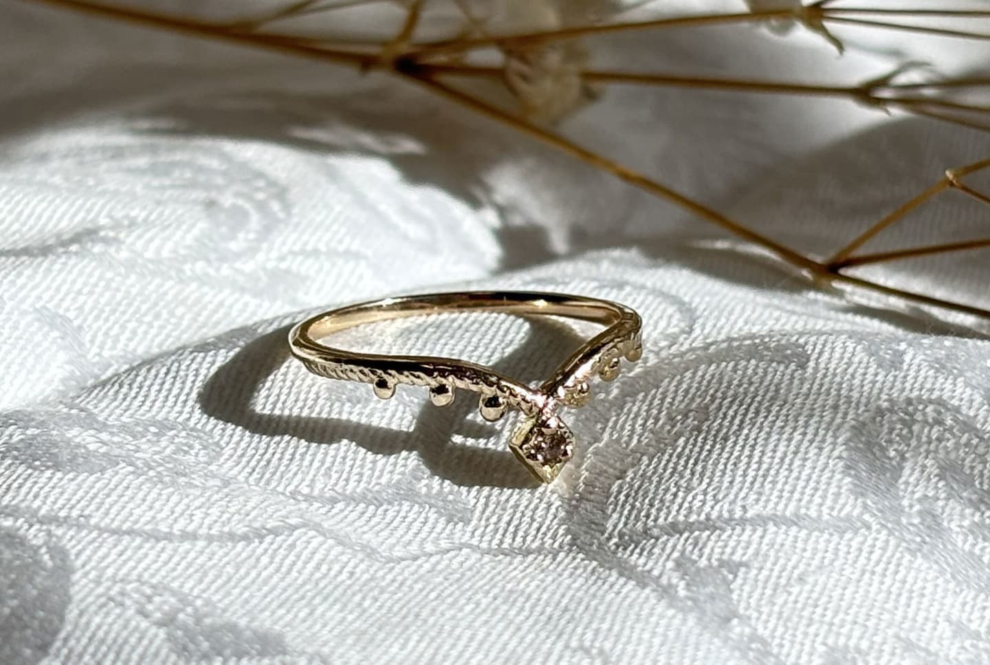 compassシリーズより、ブルーのカラーチェンジフローライトが中石のCelestiaを指に着用している写真。