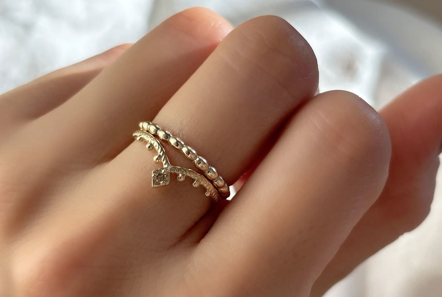 K10製のブラウンダイヤが輝く指輪、Veiled TikkaEllipse Harmonyを重ね付けしている着用写真